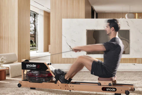 A man in black athletic wear is using a Snode wooden rowing machine in a modern living room. 